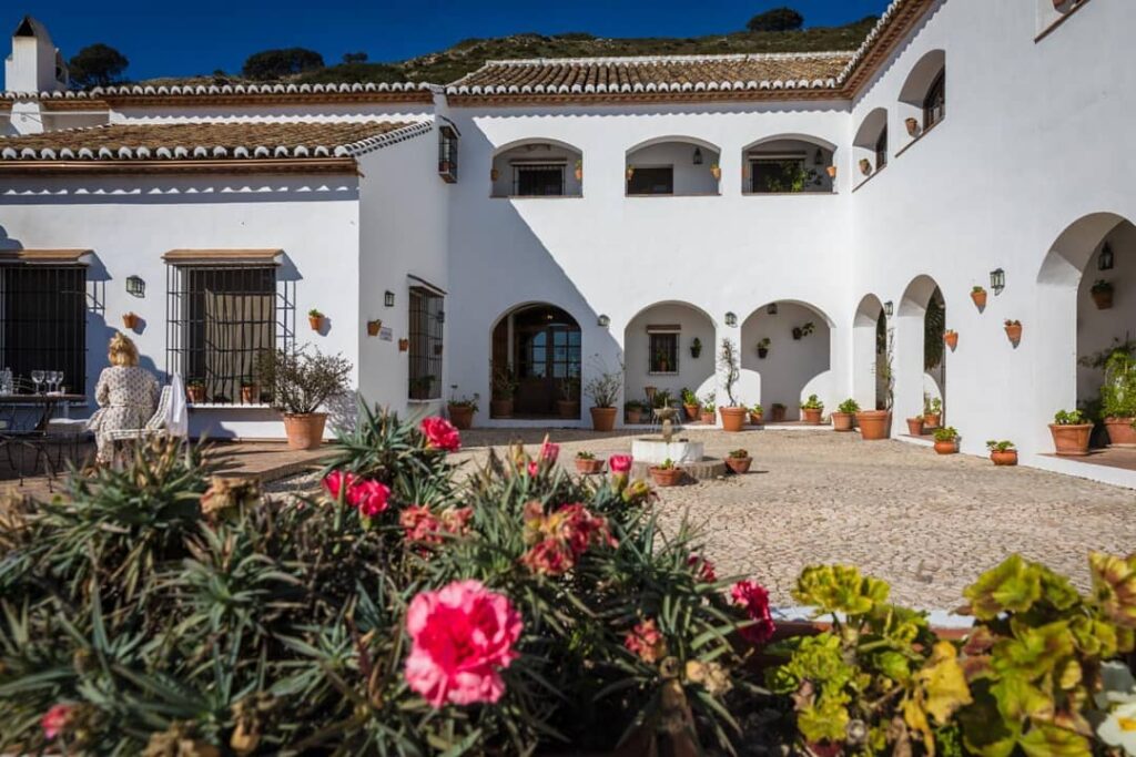 Fuente del Sol — witte Andalusische binnenplaats met bogen en bloemen